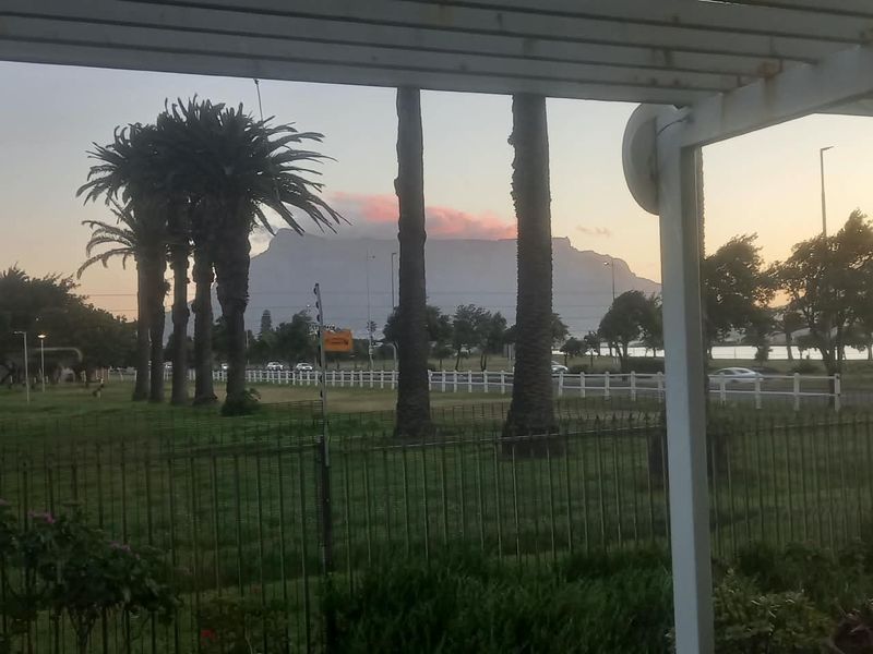 Scenic view of Table Mountain framed by a pergola and garden fencing, capturing the natural landscape and surrounding greenery.