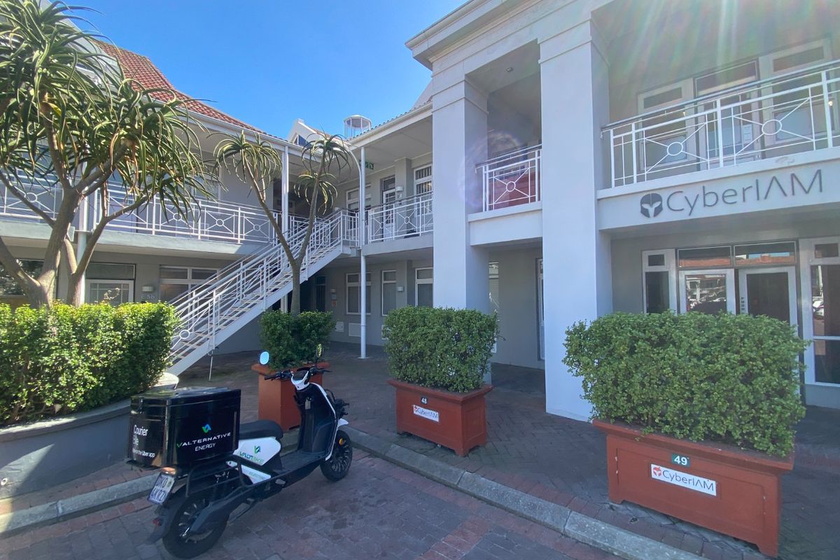 A well-maintained commercial courtyard featuring paved flooring, metal staircases, and balcony access with integrated planters.