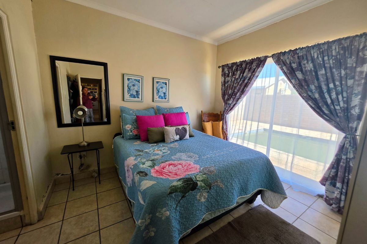 A bedroom featuring tiled flooring and a sliding glass door providing direct access to the pool area.