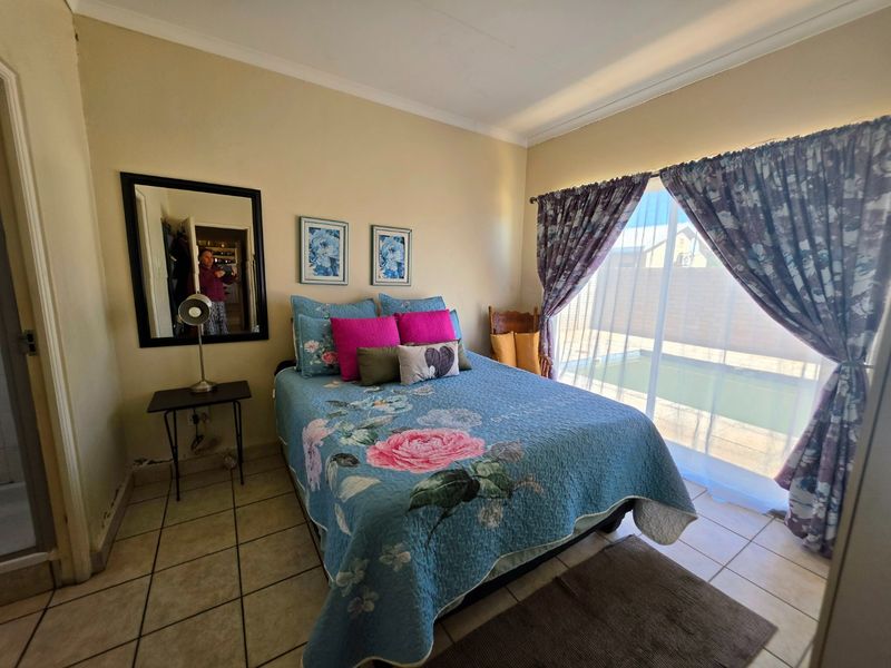 A bedroom featuring tiled flooring and a sliding glass door providing direct access to the pool area.