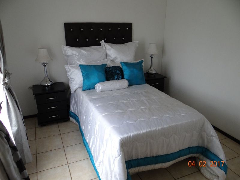 A bedroom featuring tiled flooring and neutral wall finishes.