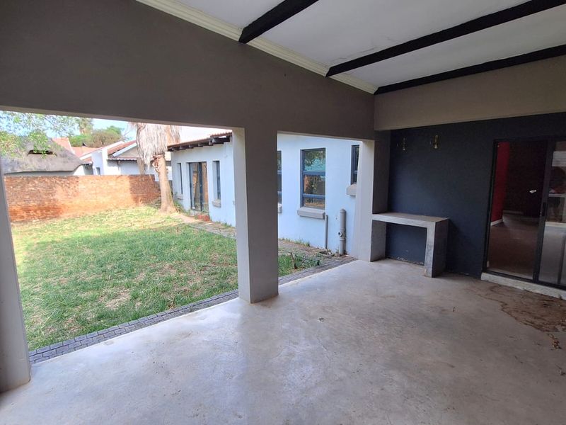 A covered outdoor patio area featuring concrete flooring, a built-in concrete counter, and sliding glass door access to the interior living space.