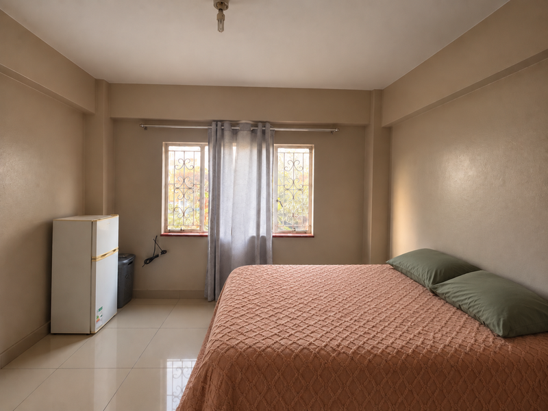 A bedroom featuring tiled flooring and windows fitted with security bars, offering a neutral canvas for personalization.