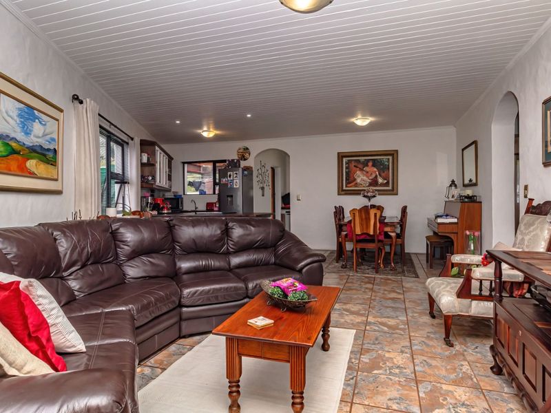 Spacious open-plan living and dining area featuring tiled flooring, a tongue and groove ceiling, and seamless flow into the adjacent kitchen space.