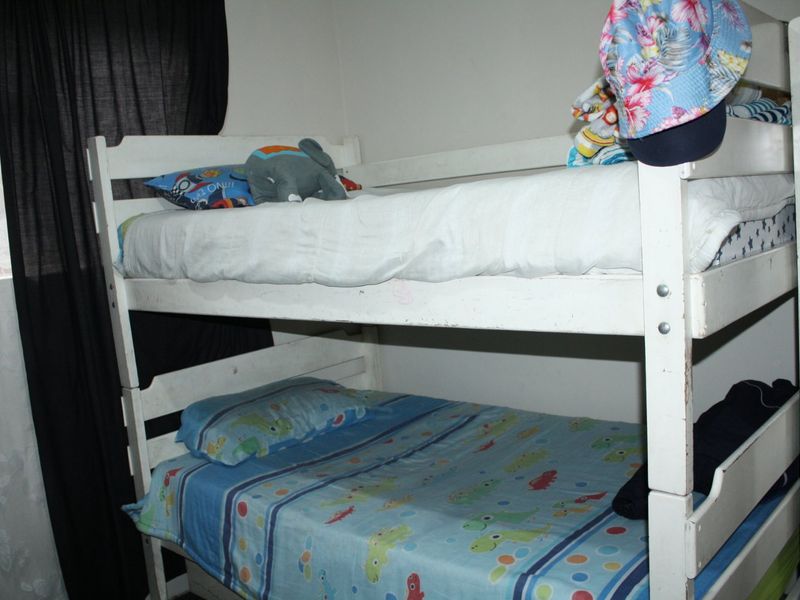 A bedroom featuring a bunk bed setup, suitable for children or guests, with neutral wall finishes.