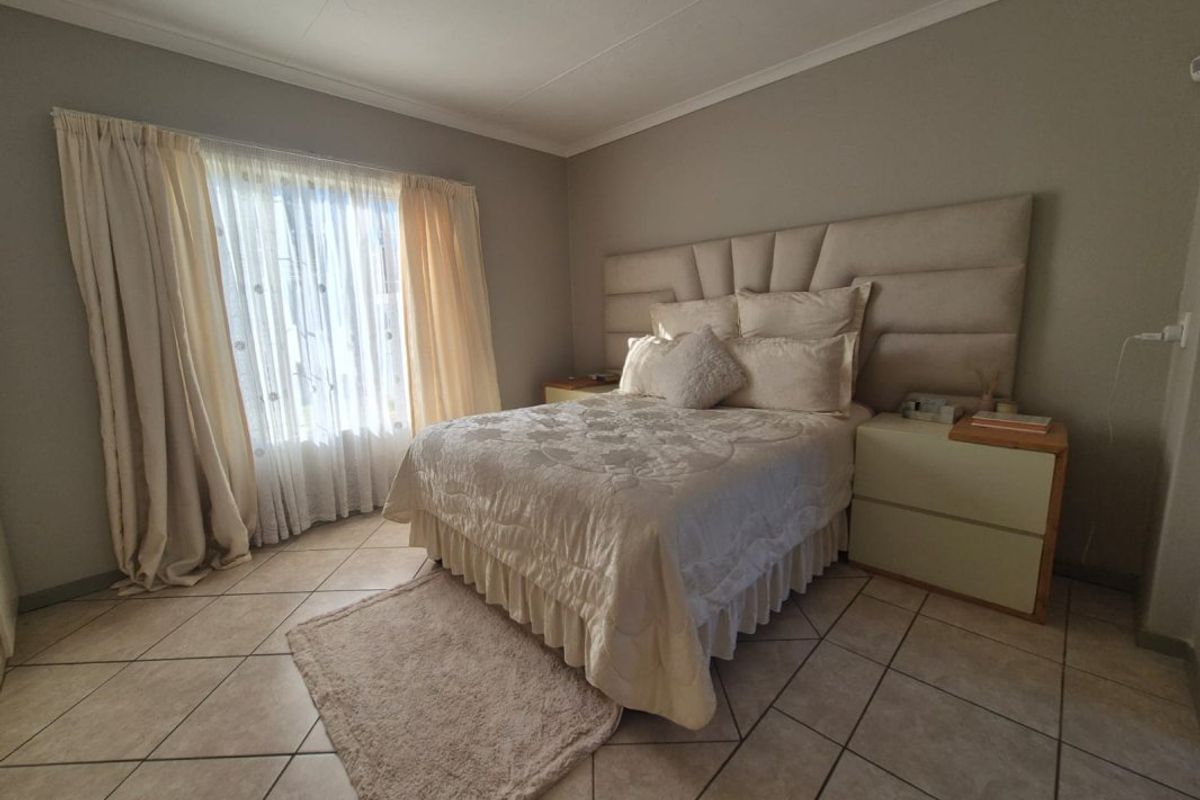 A well-maintained bedroom featuring neutral wall tones, tiled flooring, and a coved ceiling, providing a comfortable and functional living space.