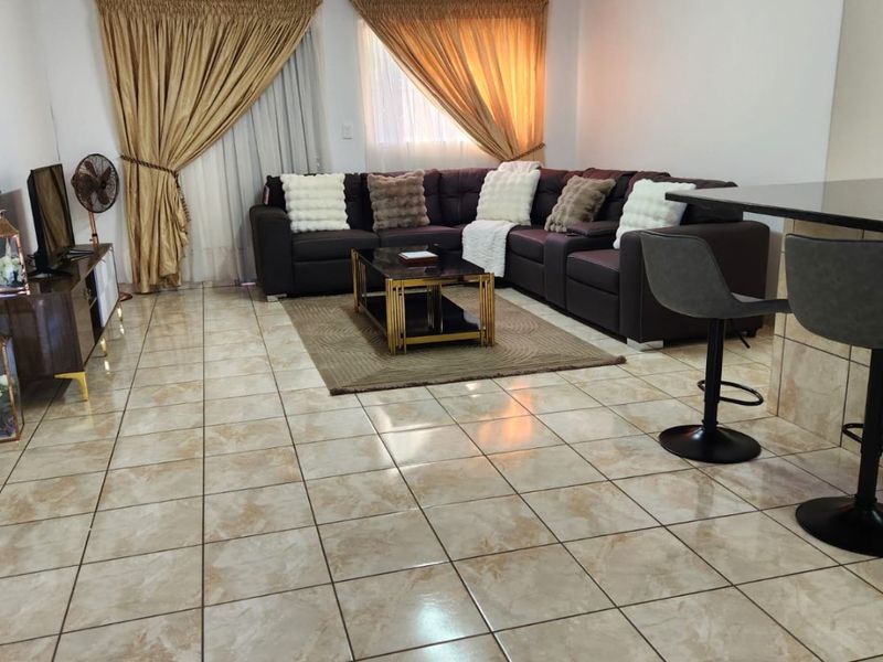 Spacious open-plan living area featuring ceramic floor tiles and a breakfast bar, offering a functional layout for modern townhouse living.