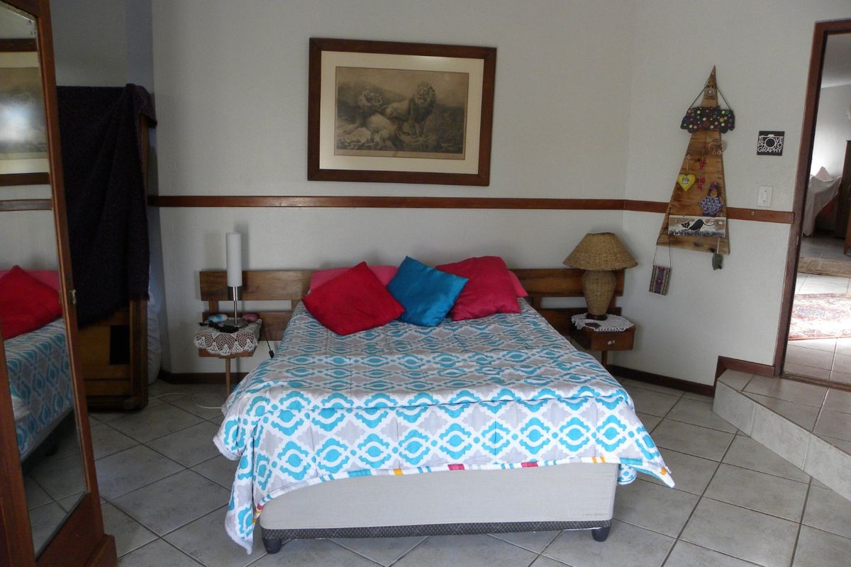A bedroom featuring tiled flooring, a wooden dado rail, and a built-in headboard.