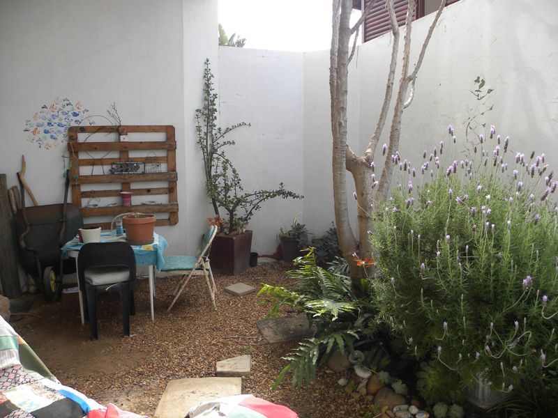 A small, enclosed garden area featuring gravel ground cover and established perimeter walls, offering a private outdoor space with potential for landscaping improvements.