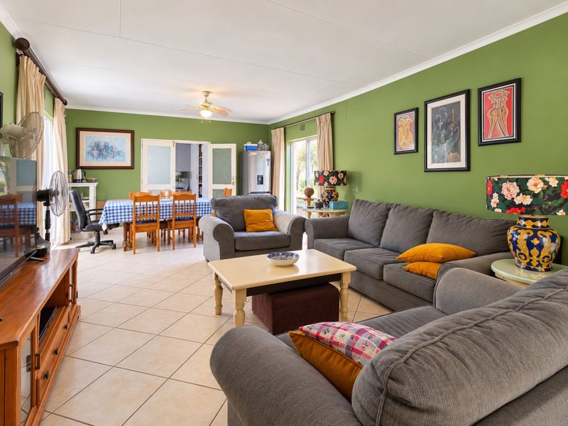 Spacious open-plan living and dining area featuring tiled flooring, a ceiling fan, and direct access to the outdoor space through sliding glass doors.