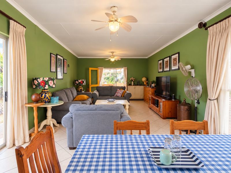 Spacious open-plan living and dining area featuring tiled flooring, dual ceiling fans, and large sliding glass doors providing access to the outdoors.