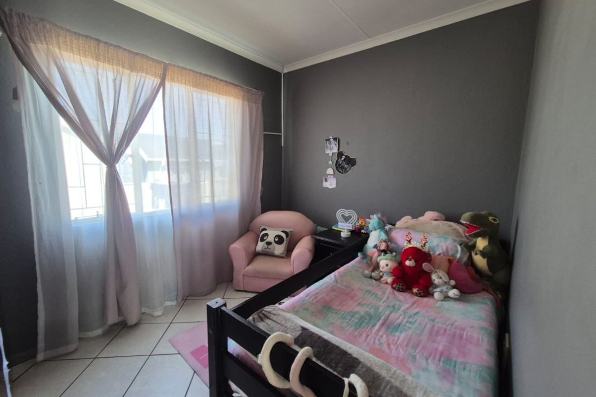 A bedroom featuring tiled flooring and neutral wall finishes, providing a functional space with natural light through the window.