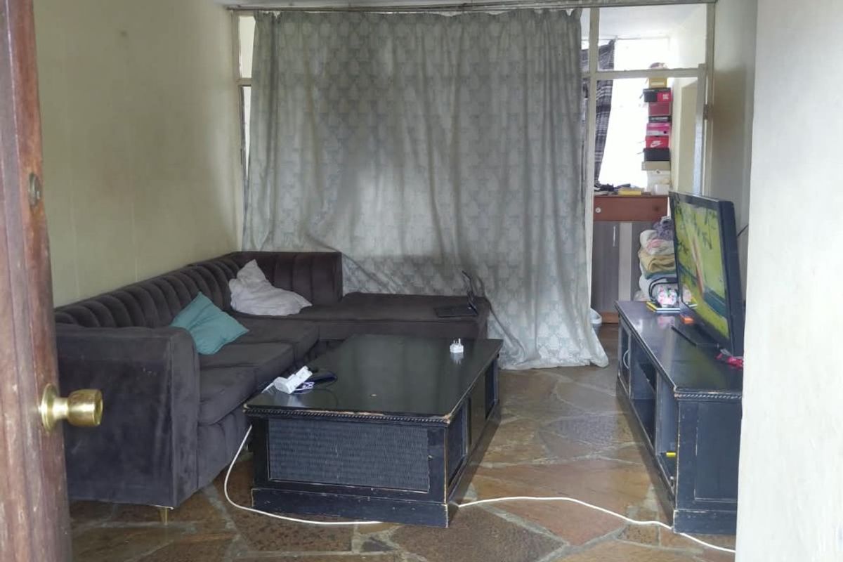 Living room featuring rustic flagstone flooring and access to a balcony area through a sliding glass door.