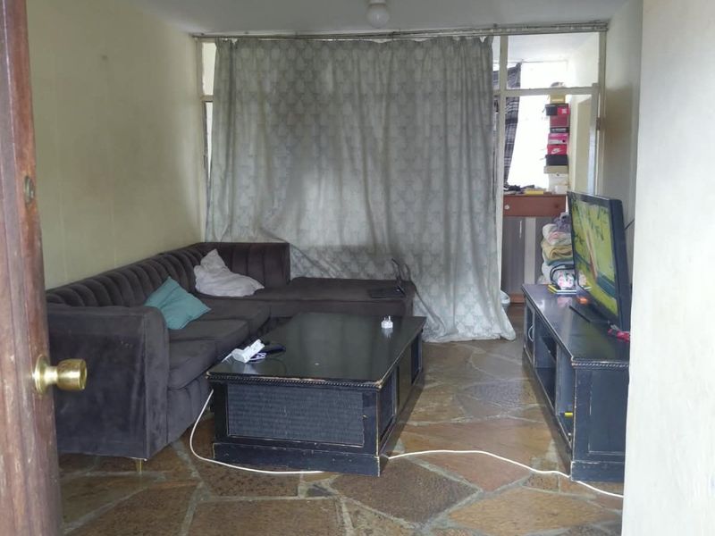Living room featuring rustic flagstone flooring and access to a balcony area through a sliding glass door.
