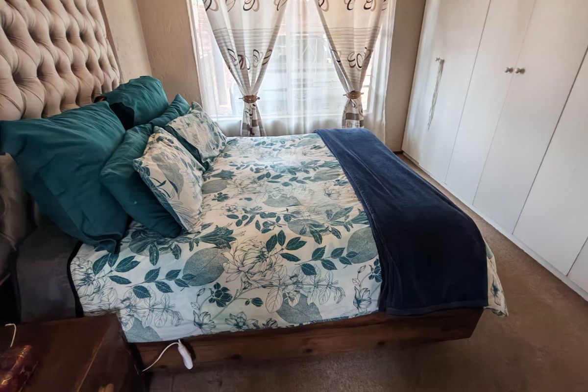 A bedroom featuring built-in cupboards and carpeted flooring, providing functional storage space.