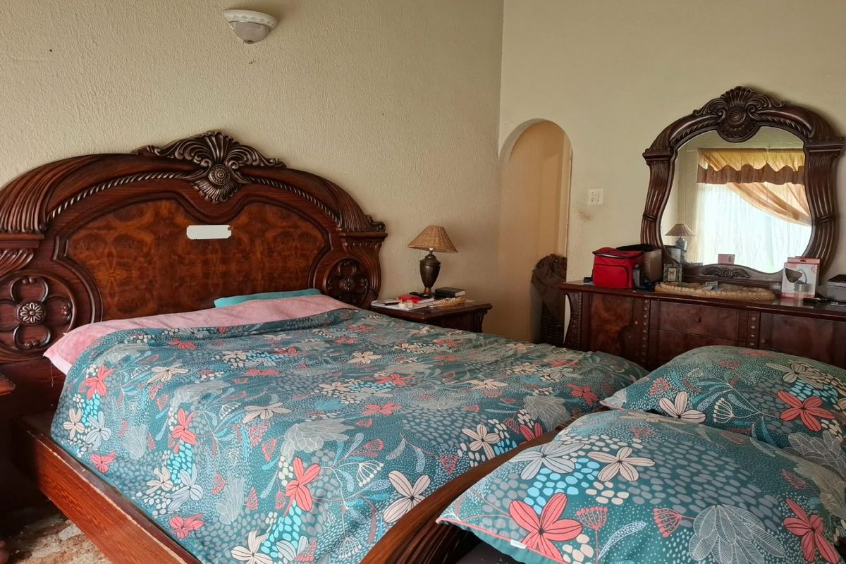 A bedroom featuring an arched doorway and a wall-mounted light fixture, providing a functional space with traditional architectural elements.