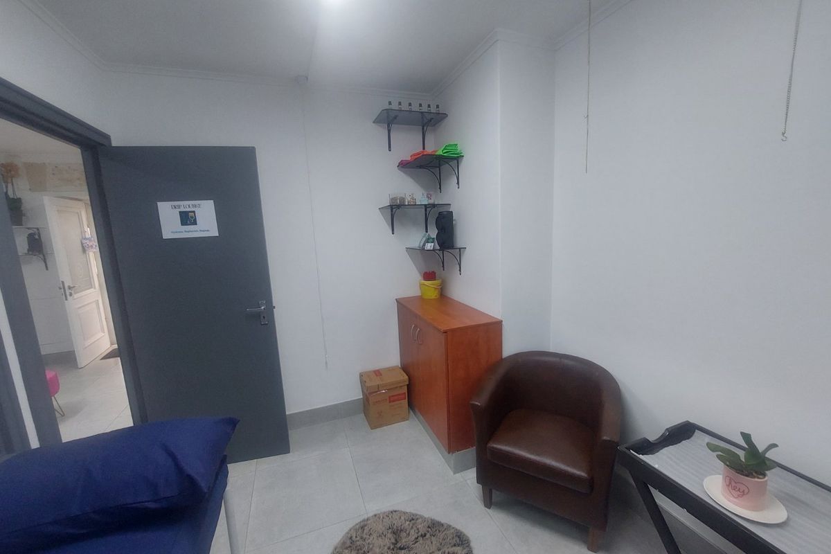 A functional utility or treatment room featuring tiled flooring, built-in wall shelving, and a neutral interior finish.