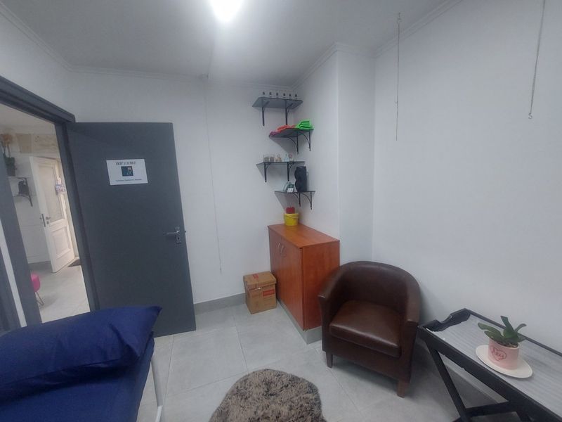 A functional utility or treatment room featuring tiled flooring, built-in wall shelving, and a neutral interior finish.