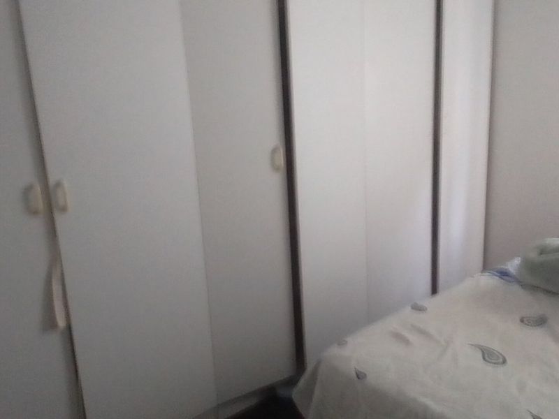 A bedroom featuring built-in cupboards with white doors.