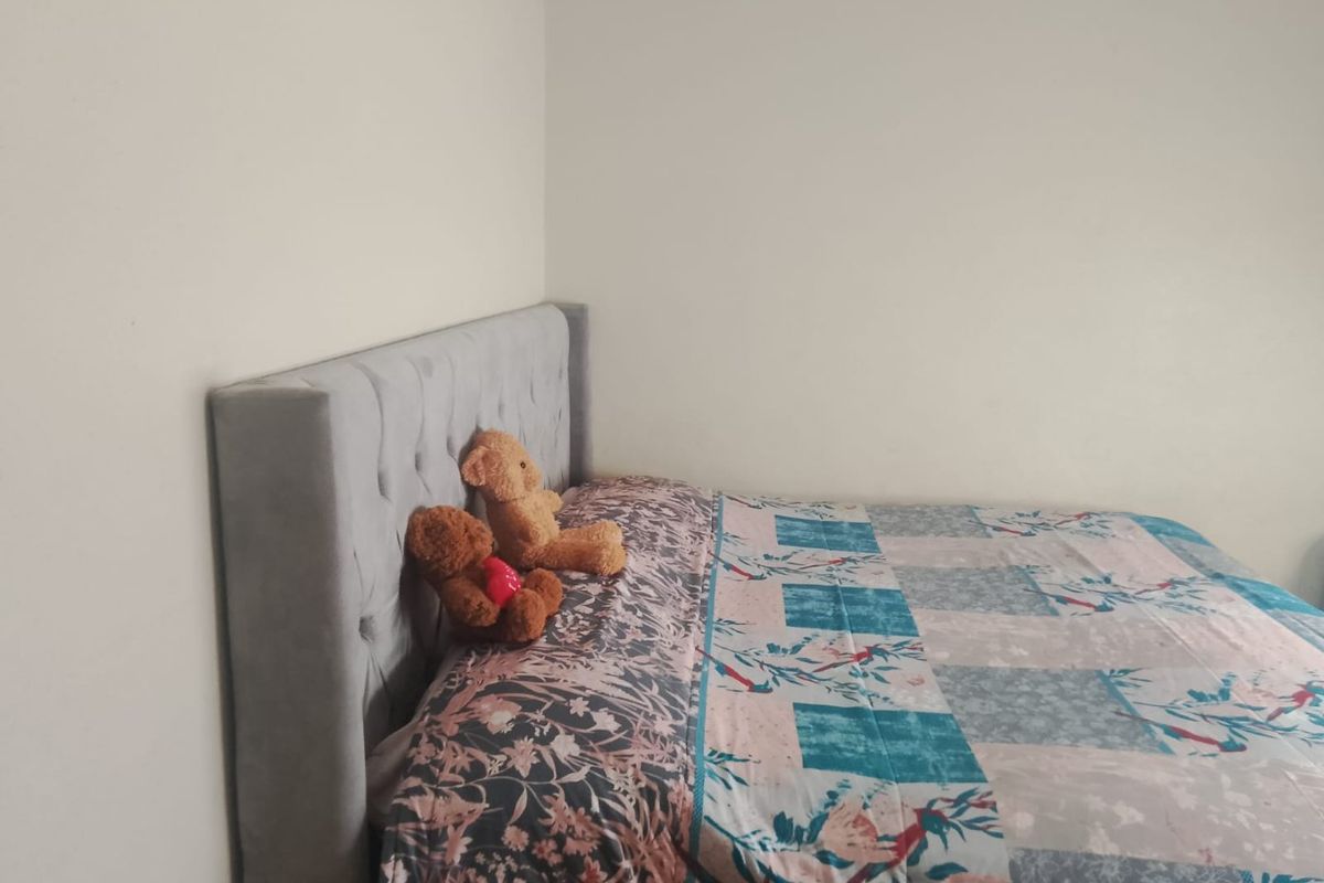 A simple bedroom space featuring neutral wall finishes, suitable for various interior design styles.