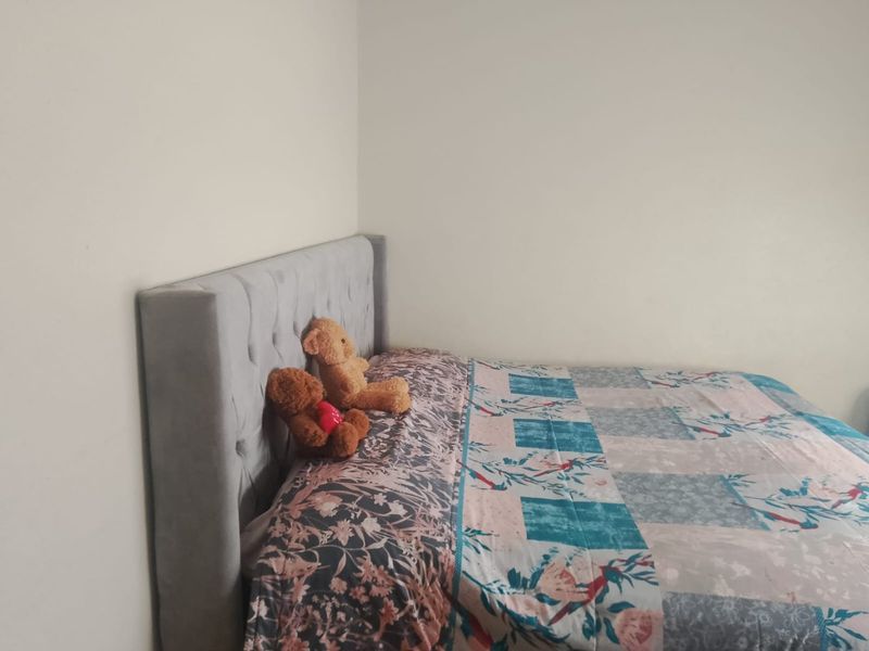 A simple bedroom space featuring neutral wall finishes, suitable for various interior design styles.