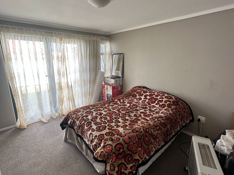 A bedroom featuring carpeted flooring and a sliding glass door providing natural light and access to the exterior.
