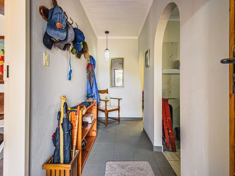 A functional hallway featuring tiled flooring, an arched entryway, and a classic tongue and groove ceiling design.