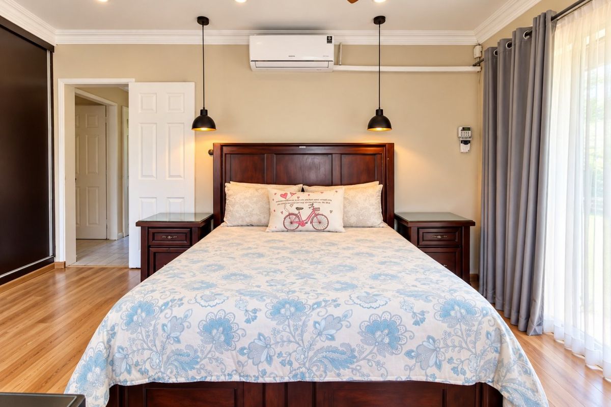 Spacious bedroom featuring laminate flooring, recessed lighting, a ceiling fan, split-system air conditioning, and direct access to an outdoor area via sliding glass doors.