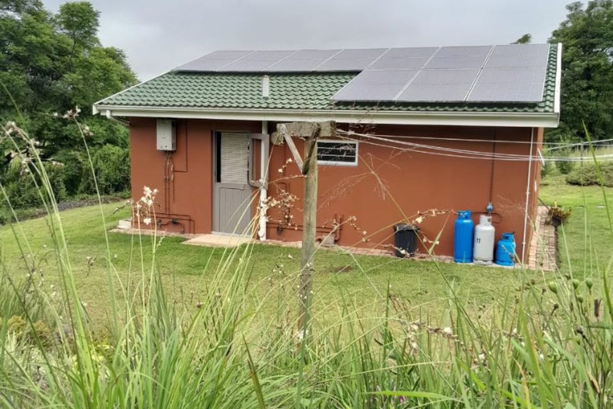Rear view of the property featuring a tiled roof with installed solar panels and external gas infrastructure.