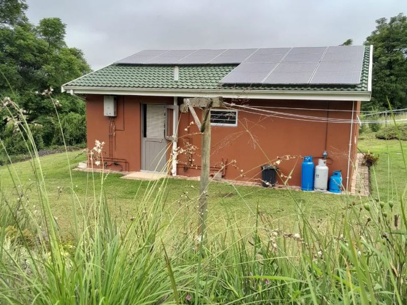 Rear view of the property featuring a tiled roof with installed solar panels and external gas infrastructure.