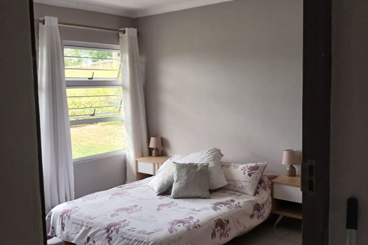 A bedroom featuring tiled flooring, recessed ceiling lighting, and a louvered window providing natural light.