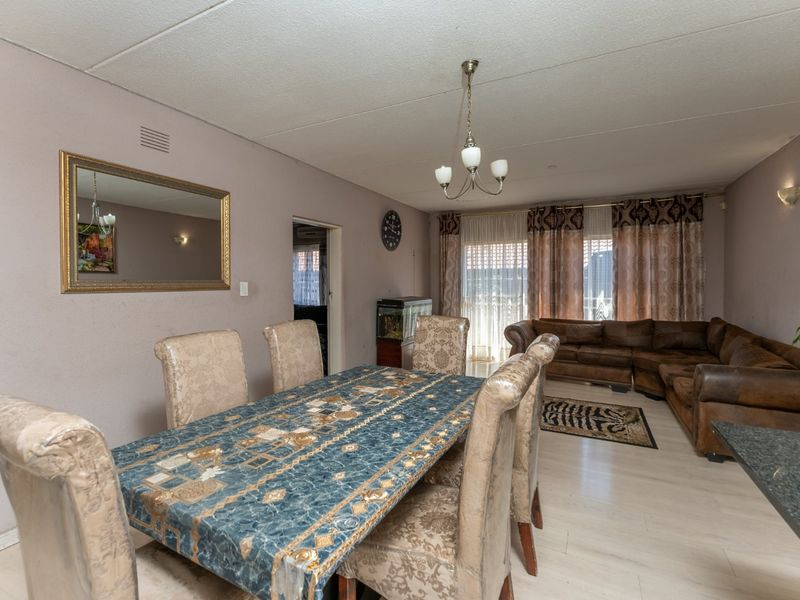 Open plan living and dining area featuring laminate flooring and access to the outdoors through a sliding glass door.