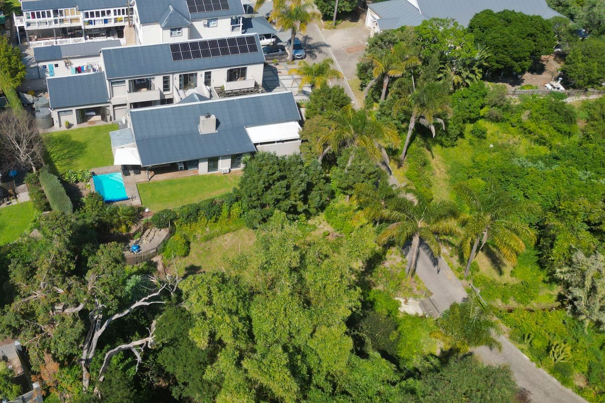 Aerial view of the property showcasing the main residence, swimming pool, landscaped garden, and surrounding neighborhood context.