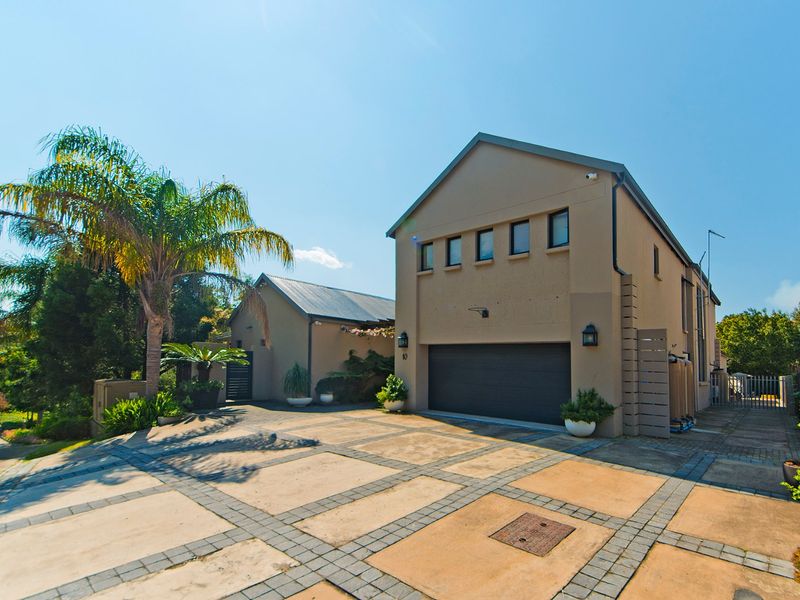 Front elevation of a modern house featuring a double garage, paved driveway, and well-maintained exterior finishes.