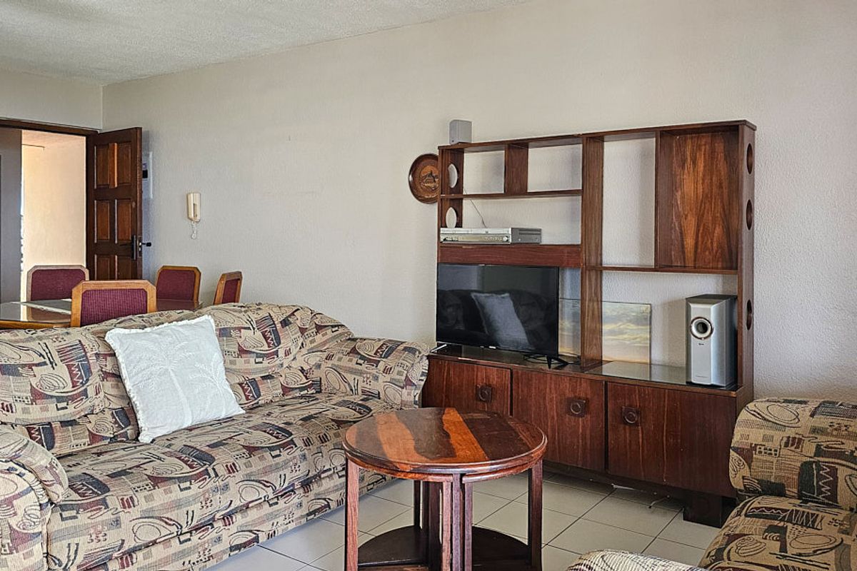 A living room area featuring tiled flooring and an intercom system, presenting a dated aesthetic that could benefit from modern updates.