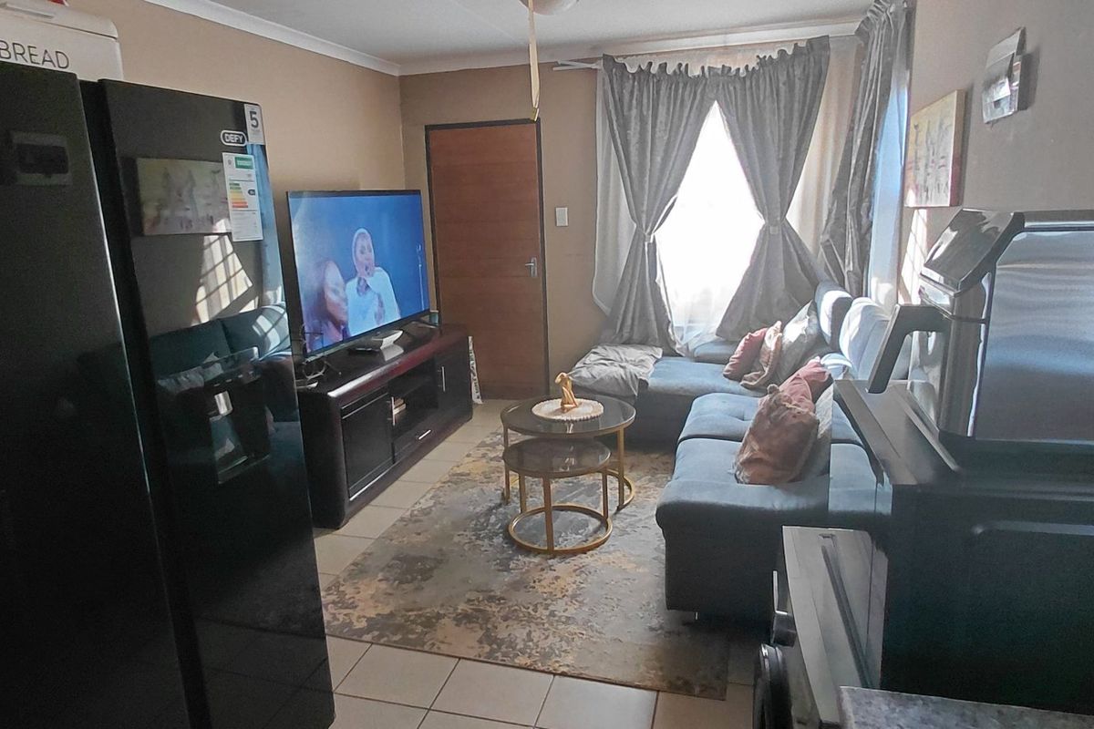 A compact living room featuring tiled flooring and coved ceiling details, providing a functional and comfortable space for relaxation.