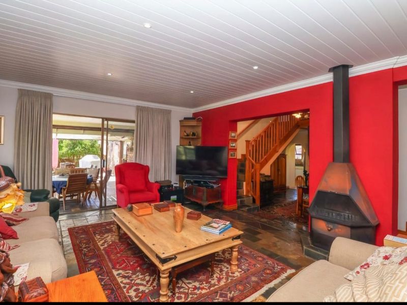 Spacious living room featuring a prominent freestanding fireplace, slate flooring, and direct access to the patio through sliding glass doors.
