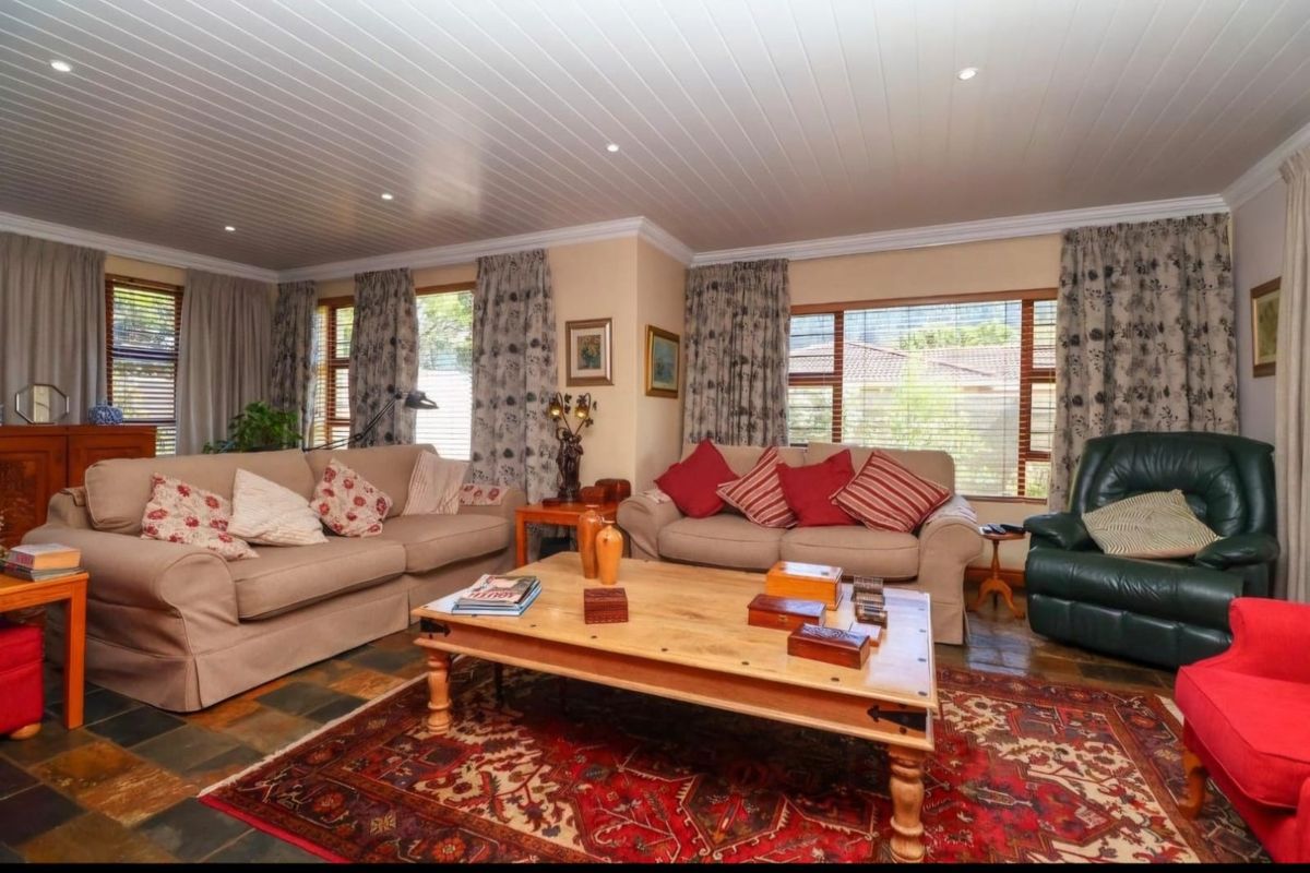 Spacious living room featuring slate tile flooring, a tongue and groove ceiling with recessed lighting, and large windows providing natural light.