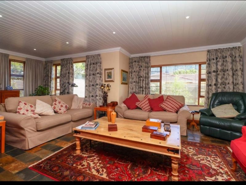 Spacious living room featuring slate tile flooring, a tongue and groove ceiling with recessed lighting, and large windows providing natural light.