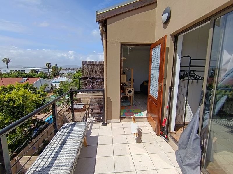 A tiled balcony featuring a metal balustrade and direct access to the interior, offering an elevated outdoor space with neighbourhood views.