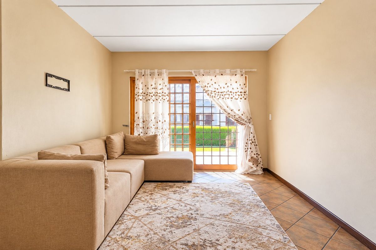 A living room featuring tiled flooring and a sliding glass door providing access to the exterior.