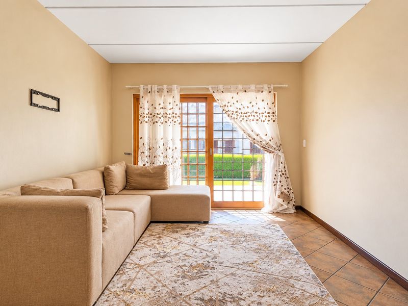 A living room featuring tiled flooring and a sliding glass door providing access to the exterior.