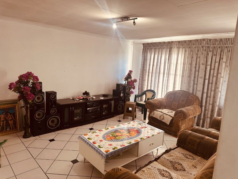 A living room featuring tiled flooring and ceiling track lighting, offering a functional space ready for modern updates.