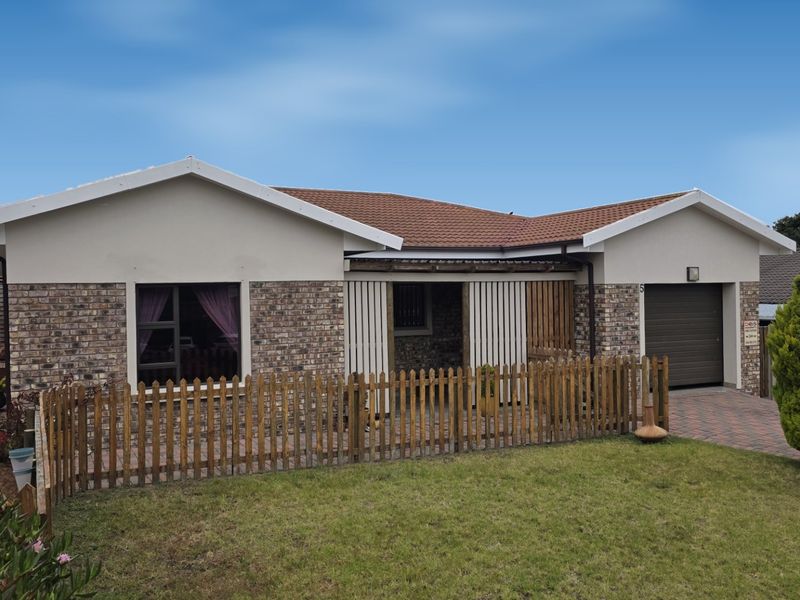 Front elevation of a single-story house featuring a brick facade, tiled roof, paved driveway, and an integrated garage.