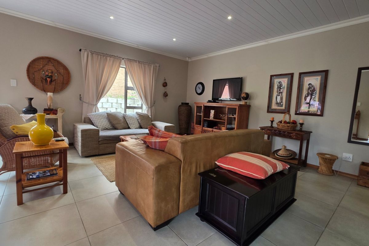 A comfortable living room featuring tiled flooring, recessed downlighting, and a tongue and groove ceiling, offering a warm and inviting atmosphere.