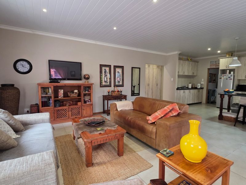 Spacious open-plan living area featuring tiled floors, recessed lighting, and a modern kitchen with granite countertops and a central island.