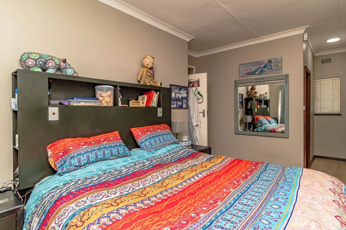 A bedroom featuring built-in cupboards, recessed downlighting, and cove cornicing, providing a functional and well-lit living space.