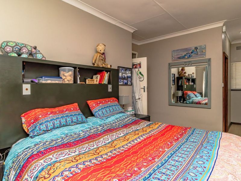 A bedroom featuring built-in cupboards, recessed downlighting, and cove cornicing, providing a functional and well-lit living space.