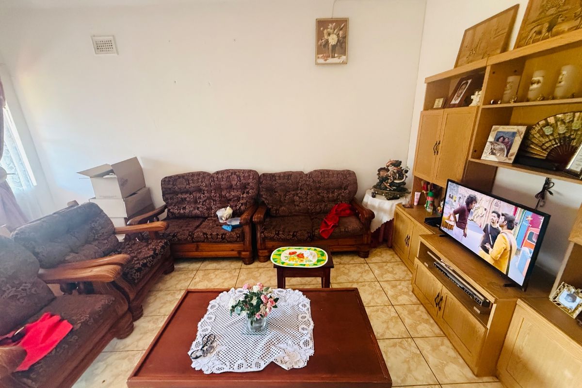A living room featuring tiled flooring and a neutral wall finish, providing a functional space for relaxation.