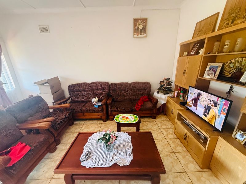 A living room featuring tiled flooring and a neutral wall finish, providing a functional space for relaxation.